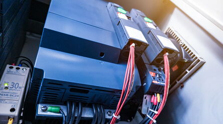 Industrial power supply units with red cables are connected for flexible testing of various applications.