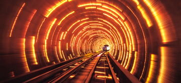 A vibrant train speeds through a glowing, futuristic tunnel, creating an electrifying railway experience.