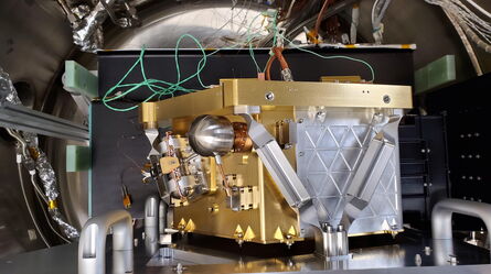 A sophisticated piece of scientific equipment with intricate wiring is displayed inside a laboratory setting.