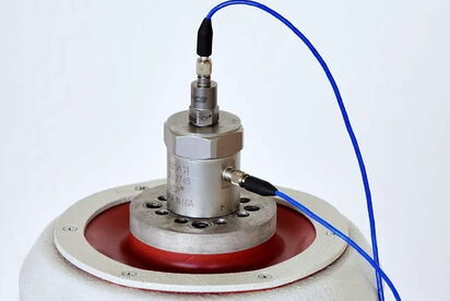 A compact sensor system with blue cables is mounted on a metal base, showcasing integrated technology from a single source.