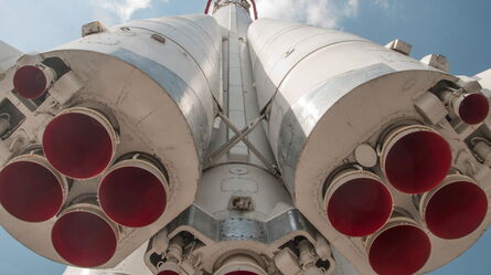 A close-up view of a rocket's powerful engines against a clear blue sky, highlighting engineering and safety integration.